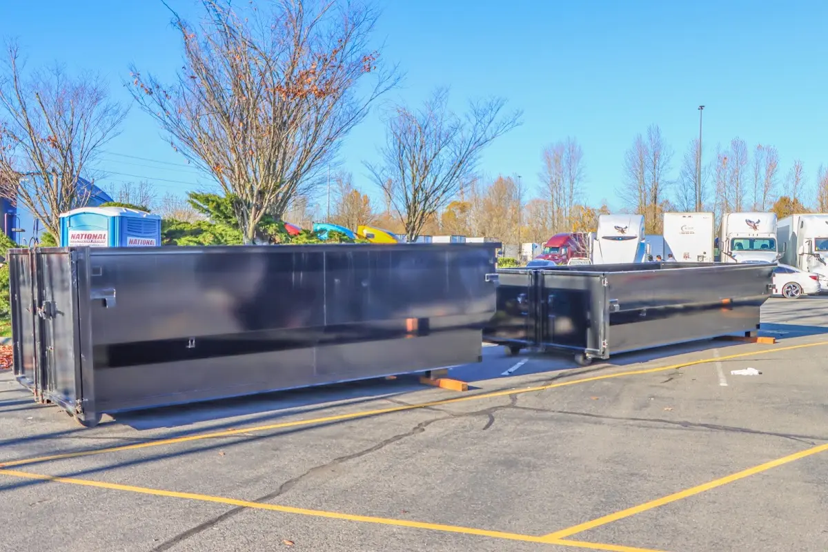 Professional dumpster rental service with roll-off container on residential driveway in Pembroke